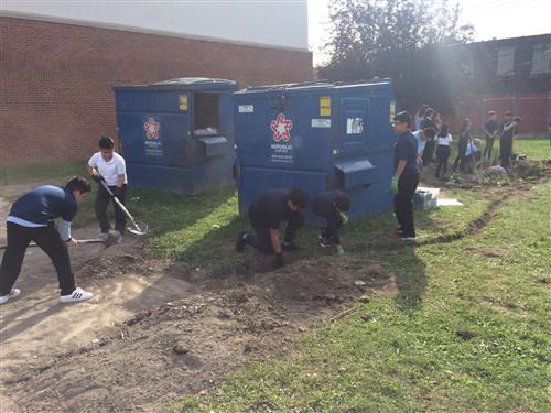  students digging a trench for a new rain garden